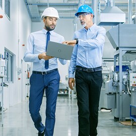 Inżynierowie przechodzą przez zautomatyzowany zakład produkcyjny