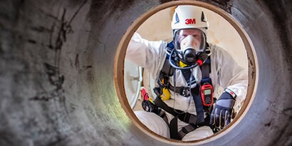 Pracownik w masce i hełmie 3M
