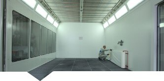  Mężczyzna nakładający materiał ochronny 3M DirtTrap na ściany kabiny lakierniczej
