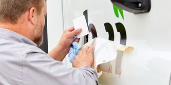Mężczyzna nakładający napisy na auto
