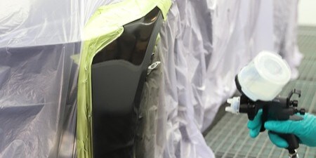 Technik polerujący panel samochodu
