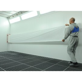 Mężczyzna nakładający materiał 3M Dirt Trap na ścianę kabiny lakierniczej 