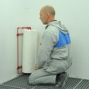 Mężczyzna rozpoczynający nakładanie materiału Dirt Trap na ścianę za pomocą aplikatora