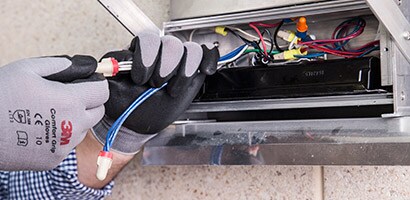 Pracownik umieszcza przewód elektryczny w odpowiednim miejscu za pomocą taśmy 3M.
