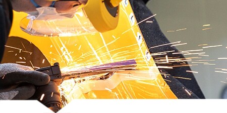Technik tnący metalową część karoserii pojazdu
