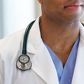 Stetoskop Littmann noszony właściwie na zewnątrz kołnierzyka białego fartucha aboratoryjnego.