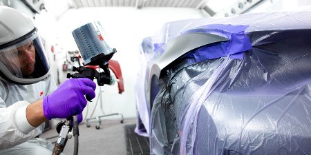 lakiernik malujący samochód pistoletem natryskowym 3M
