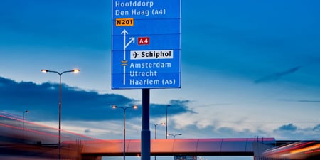 Odblaskowe znaki drogowe nad jezdnią na ruchliwej autostradzie
