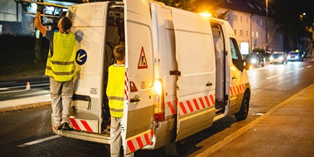 Furgonetka na poboczu drogi z ukośnymi pasami odblaskowymi
